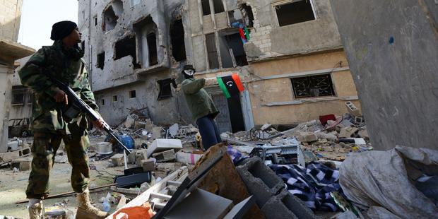 206845_A_member_of_Libyan_pro-government_forces_backed_by_locals_carries_weapon_during_clashes_with_Shura_Council_of_Libyan_Revolutionaries_in_the_streets_of_Benghazi_02