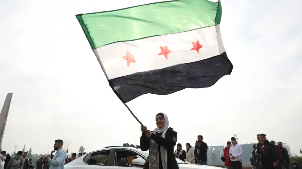 una-mujer-ondea-la-bandera-rebelde-la-nueva-ensena-nacional-de-siria-en-damasco