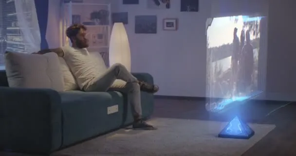depositphotos_313779682-stock-video-man-watching-holographic-tv-at