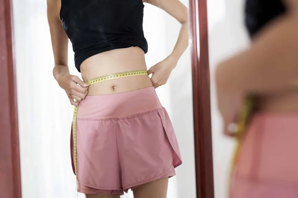 close-up-skinny-woman-measuring-her-waist-scaled