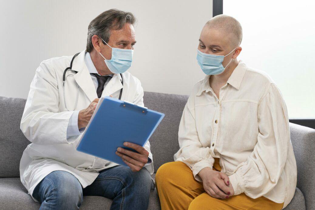 young-woman-suffering-of-breast-cancer-talking-with-her-doctor-1038x692