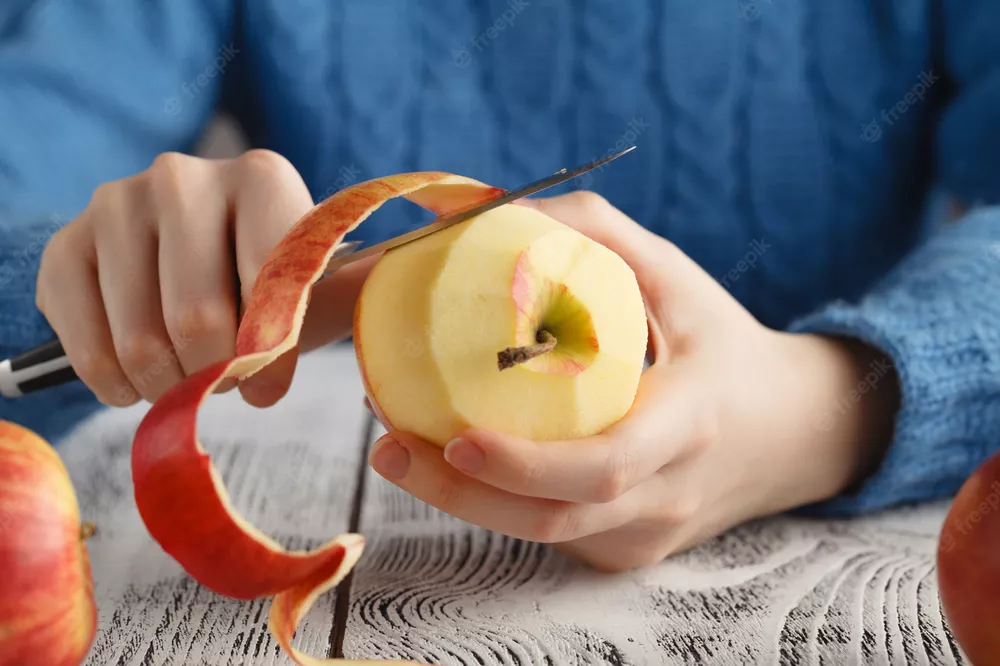 chica-pelando-manzana-mesa_155165-3251