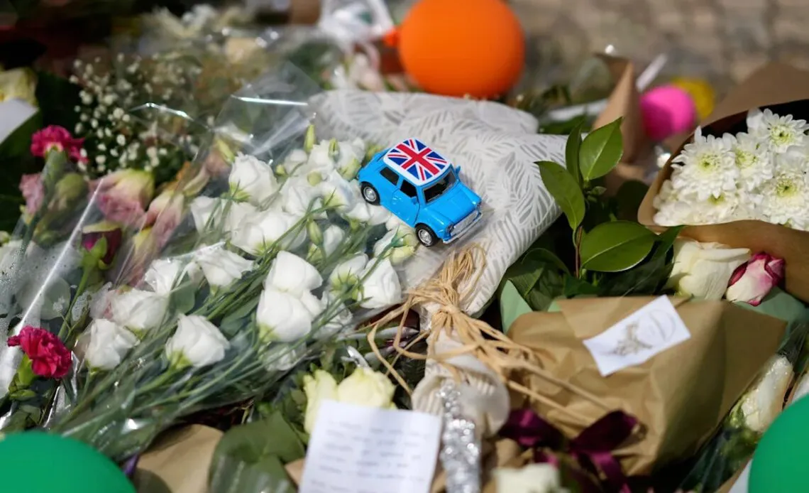 Un-carro-de-juguete-con-la-bandera-del-Reino-Unido-entre-las-flores-colocadas-en-un-altar-improvisado-en-memoria-de-los-fallecidos-en-el-descarrilamiento-del-funicular-Gloria-en-Portugal-1140x694