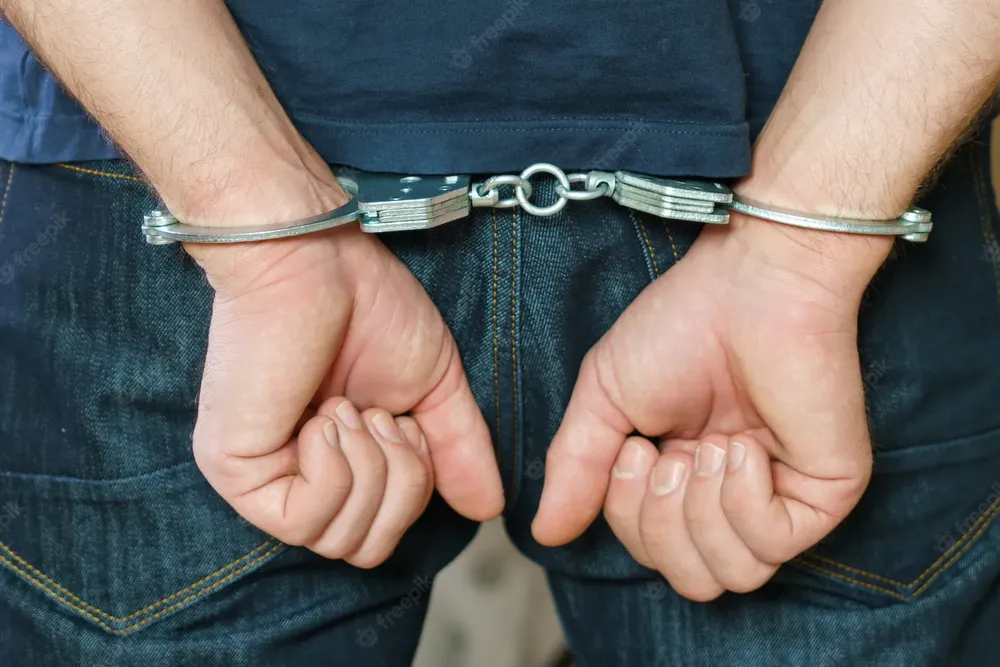 hombre-detenido-esposado-manos-espalda_168410-1295